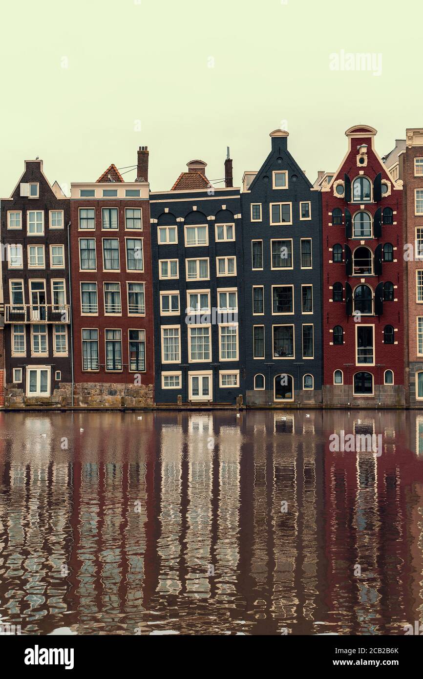 tijger Gewoon Kerel Amsterdam, Netherlands, famous dancing houses with reflection in river  Amstel, vertical image Stock Photo - Alamy