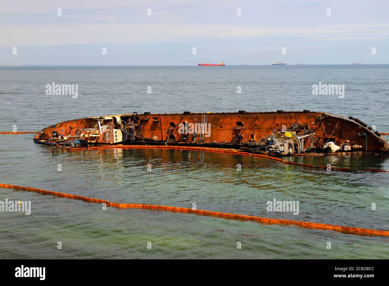 An old rusty tanker flooded and lies near the coast in Odessa, Ukraine. Oil spills from the ship and pollutes the sea water. Environmental pollution Stock Photo