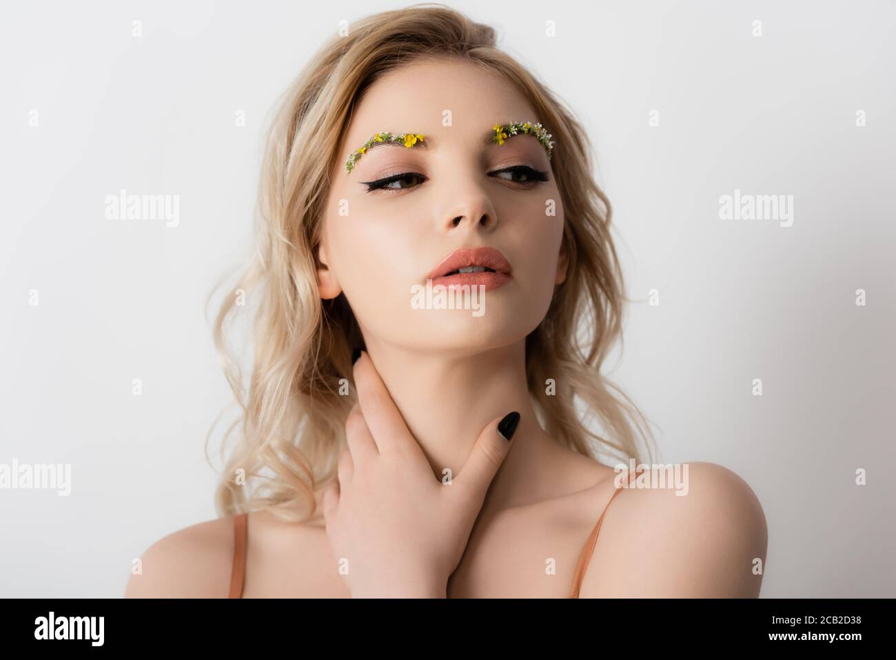 Beautiful Blonde Woman With Wildflowers On Eyebrows Touching Neck