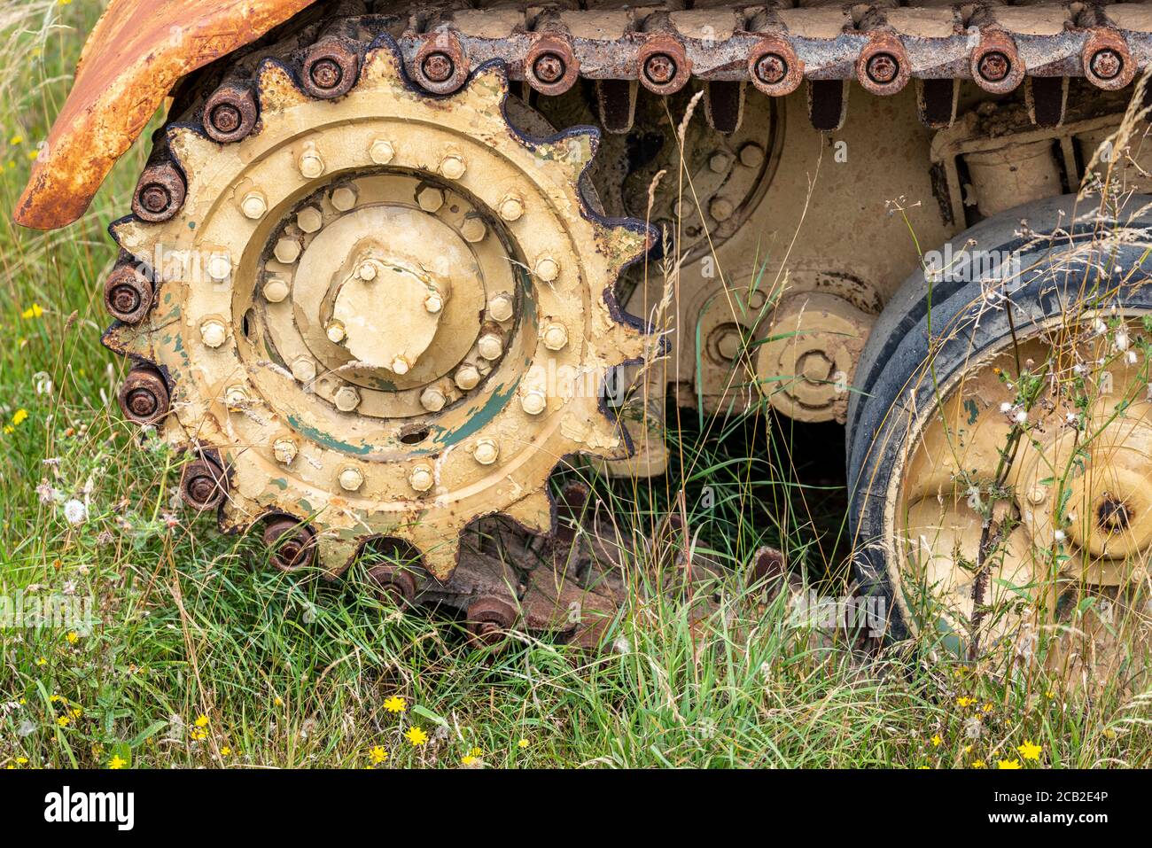 Corroding tank at Imperial War Museum, Duxford, Cambridgeshire, UK. Armoured fighting vehicle, AFV, in long grass. Out to grass. Tank tracks Stock Photo