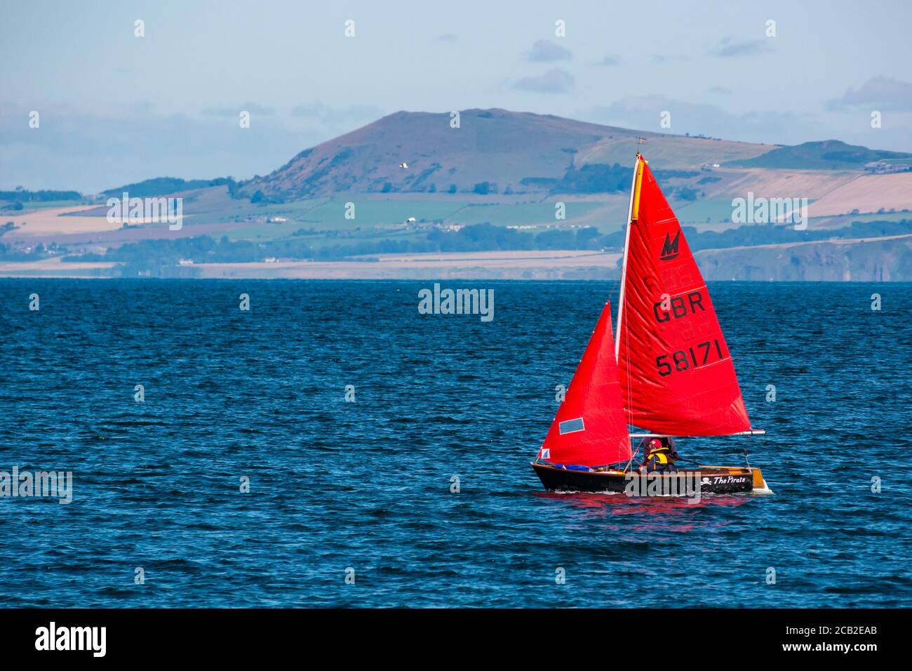 Sailing dinghy in Firth of Forth with children on board on sunny Summer day, Scotland, UK Stock Photo