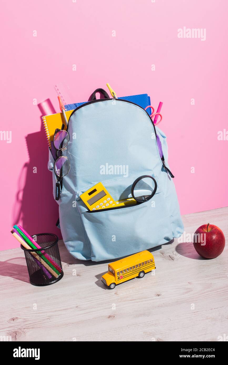School Backpack Packed With Stationery Near School Bus Model Whole school-backpack-packed-with-stationery-near-school-bus-model-whole