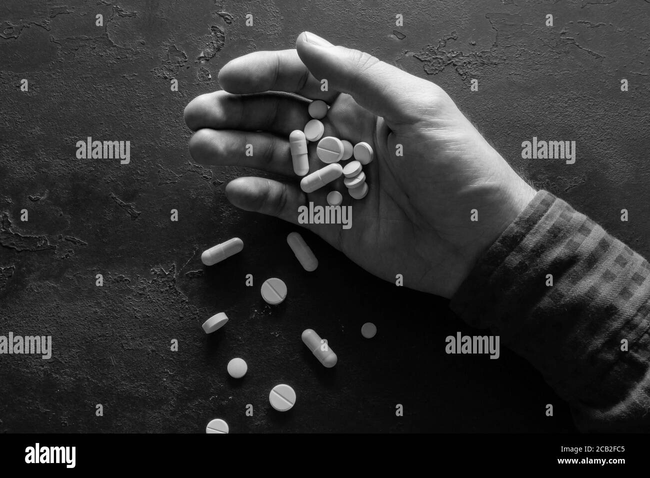 hand with pills on black background closeup concept stop suicide Stock Photo