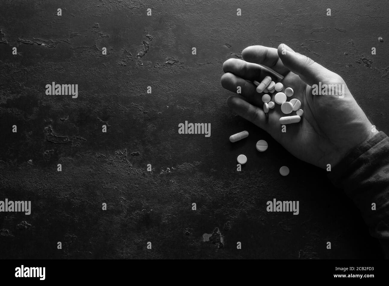 hand with pills on a black background with space for text concept stop suicide Stock Photo