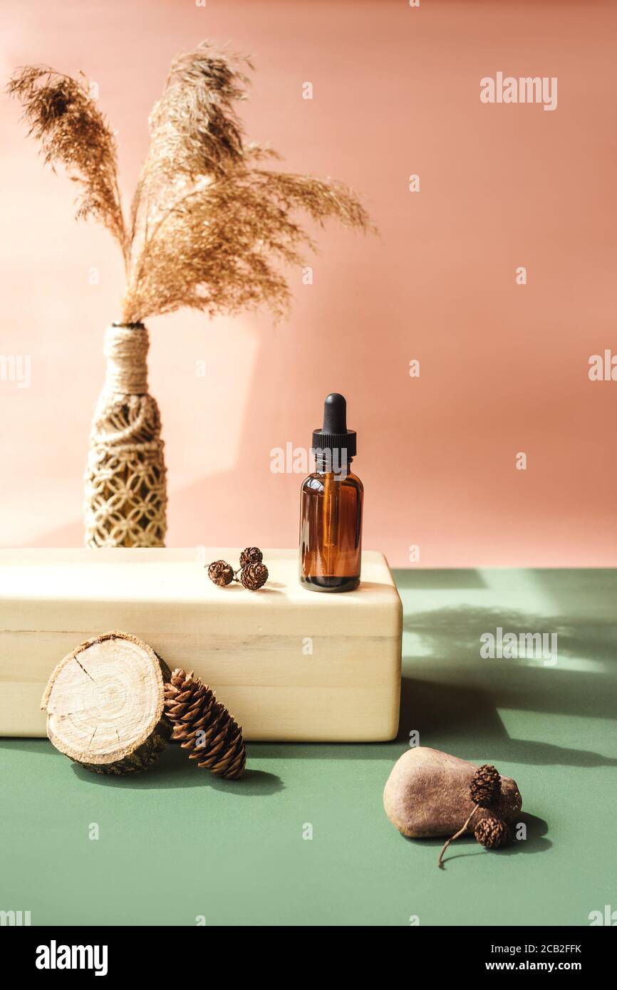 Blank amber glass essential oil bottle on wooden brick. Natural organic
