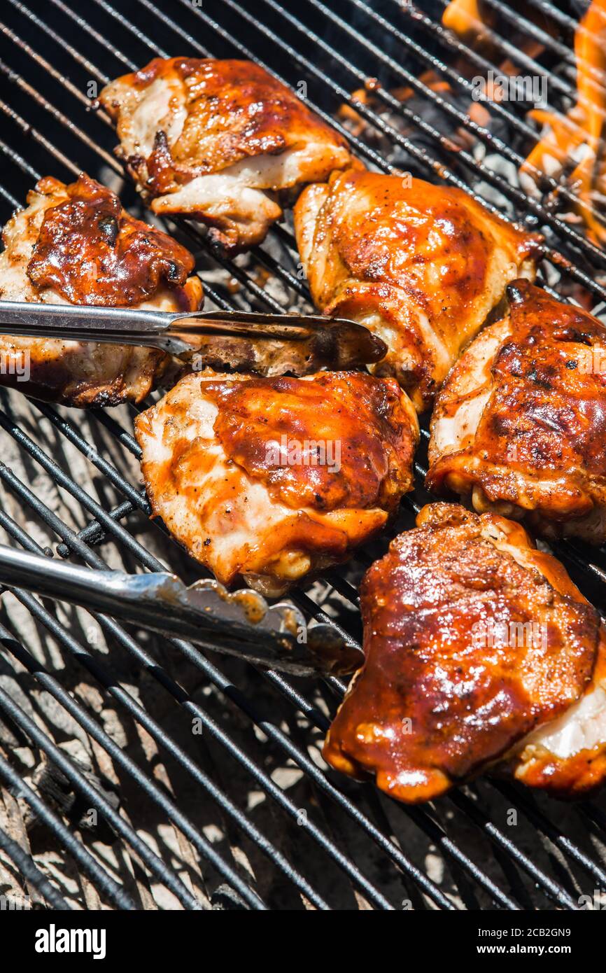 Marinated Chicken thighs glazed with a barbecue sauce cooking on a