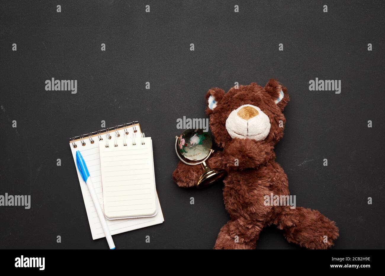 stack of notebooks with blank white sheets and a brown teddy bear ...