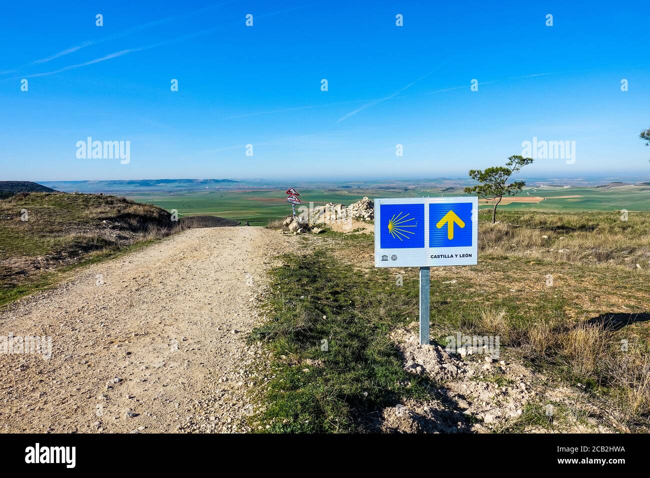Yellow Way Arrow Sign of the Camino on loney way. Impression from the Camino de Santiago de Compostela in Spain in Winter 2020. Stock Photo