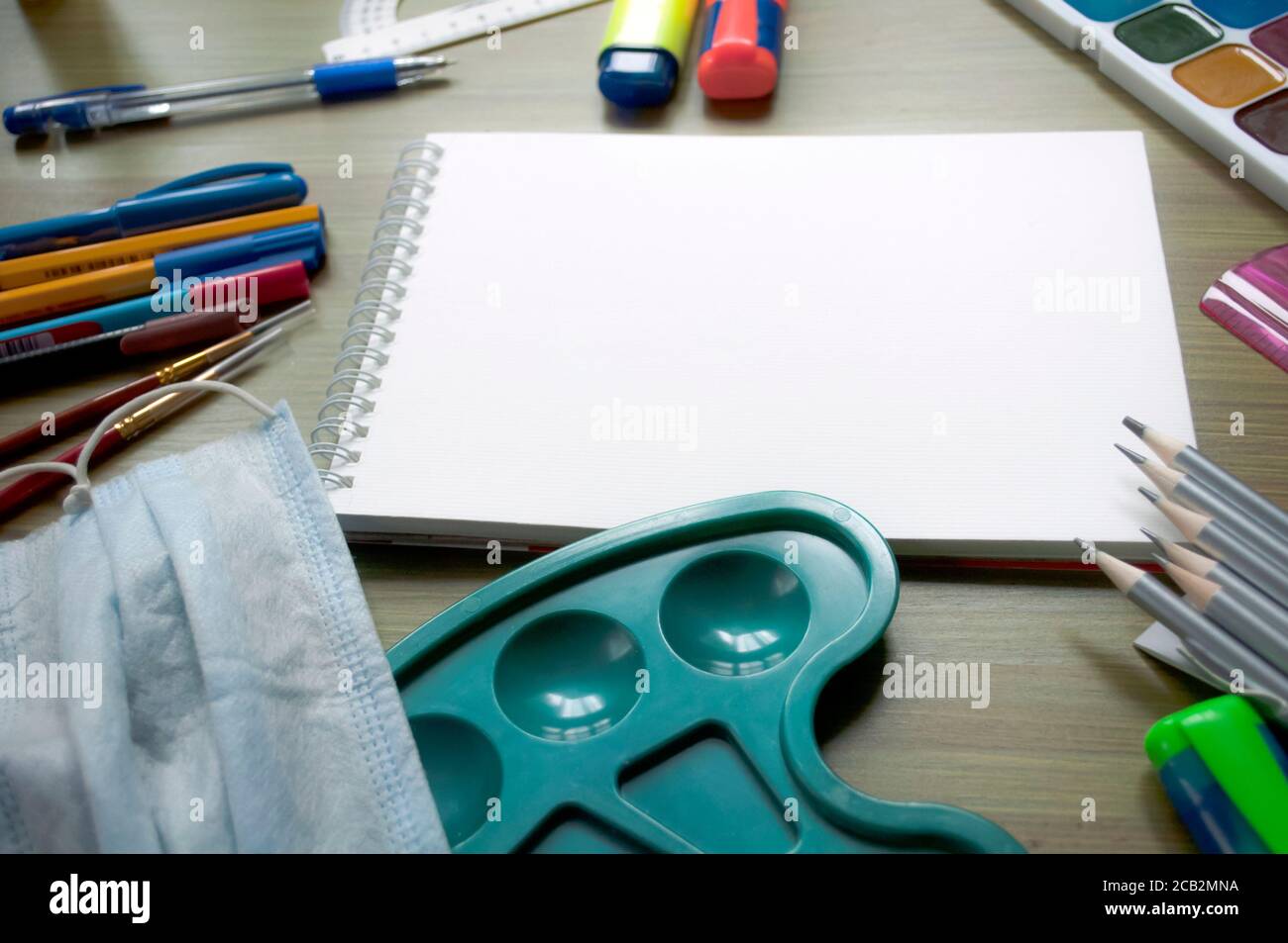 https://c8.alamy.com/comp/2CB2MNA/education-mockup-with-pupils-stationery-and-and-blank-sheet-of-white-sketchbook-paper-on-wooden-background-drawing-set-education-concept-2CB2MNA.jpg