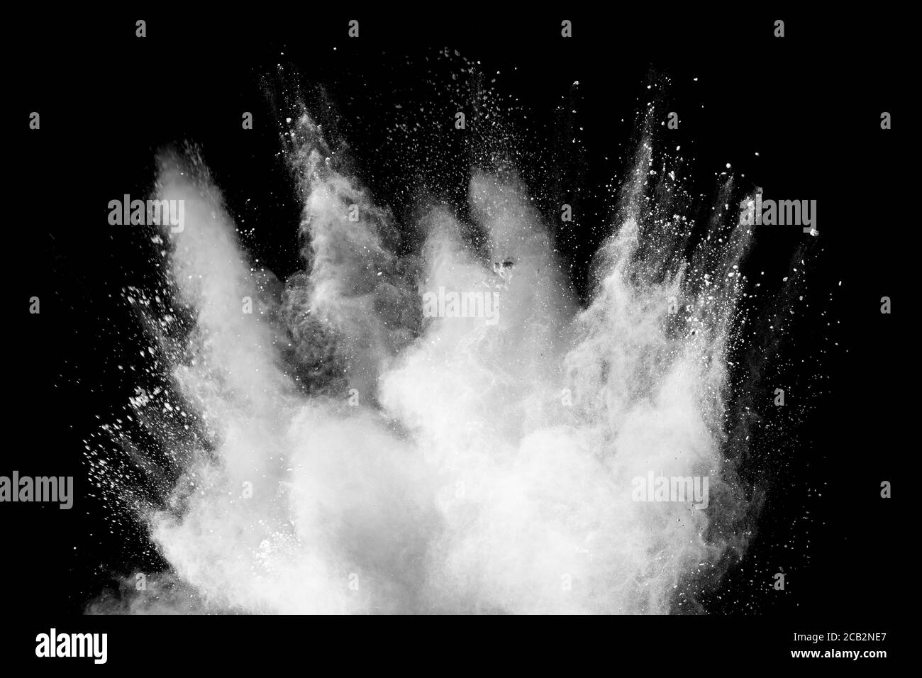 Freeze motion of white dust particles splash on black background. Stock Photo