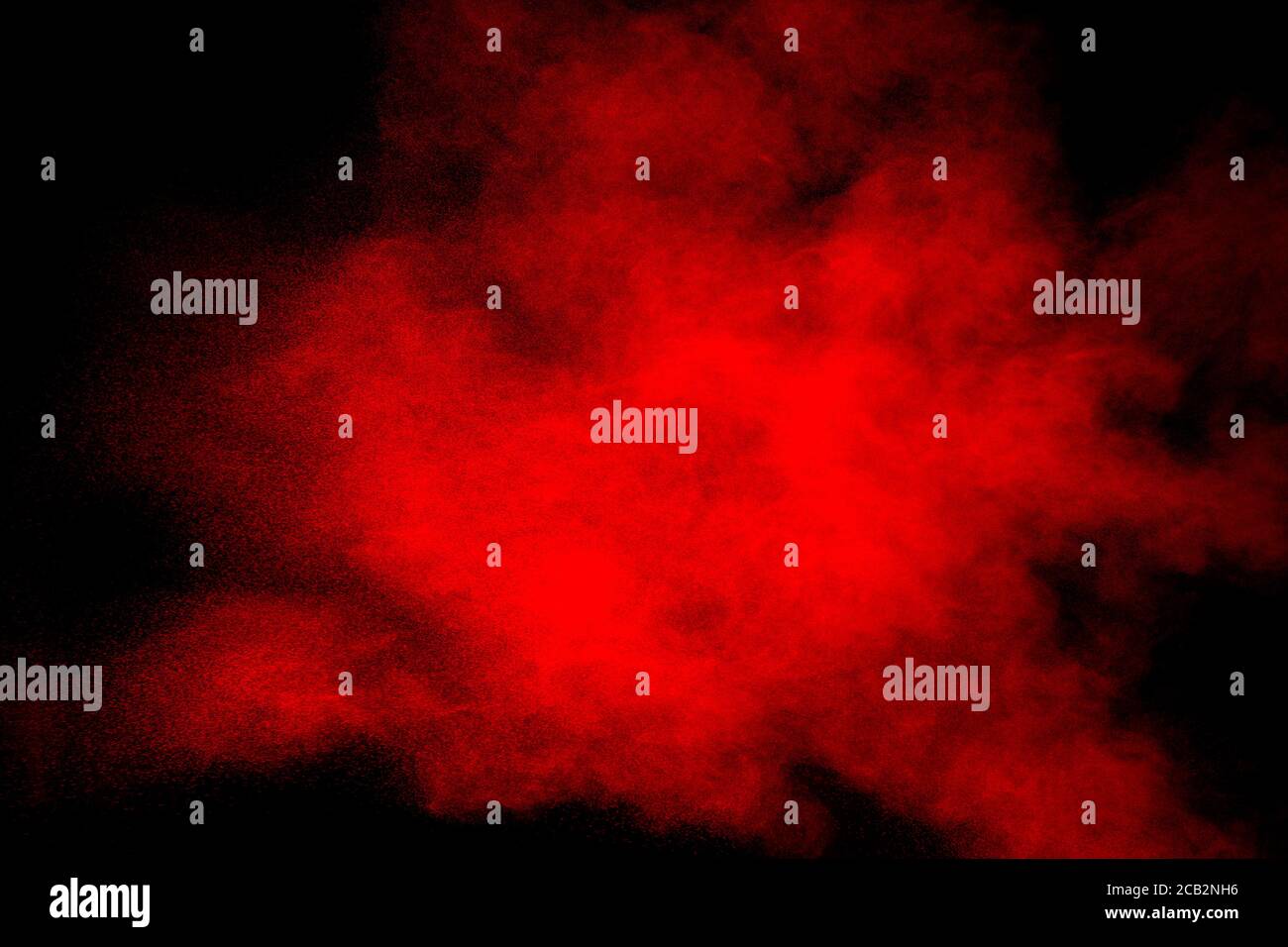 Red powder explosion on black background. Freeze motion of red dust particles splash. Stock Photo