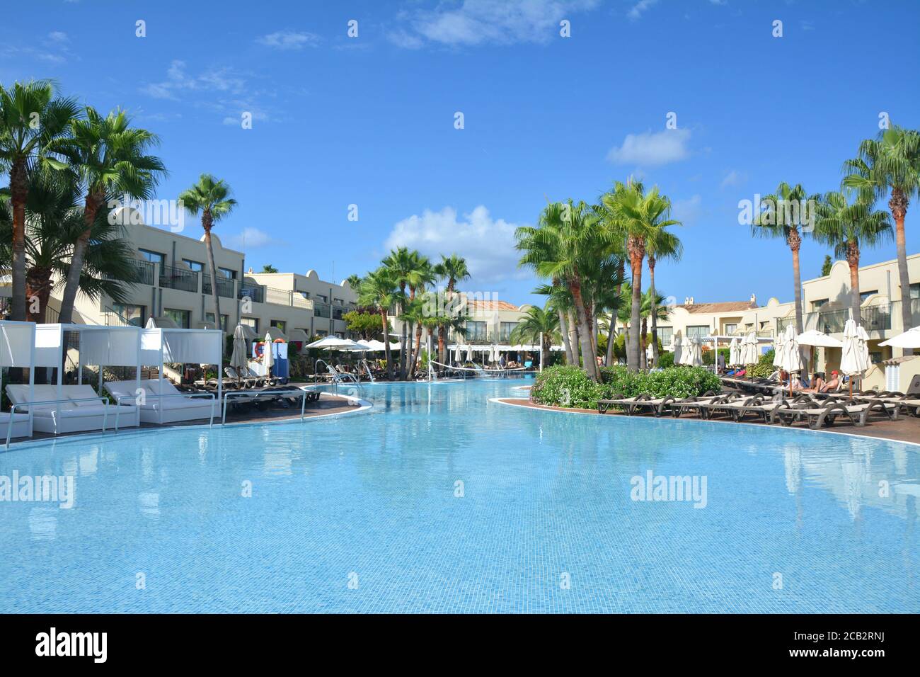 CALA'N BOSCH, MENORCA, SPAIN - AUGUST 14, 2018 : Swimming pool and palm trees in a vacation resort Valentin Star hotel. Stock Photo