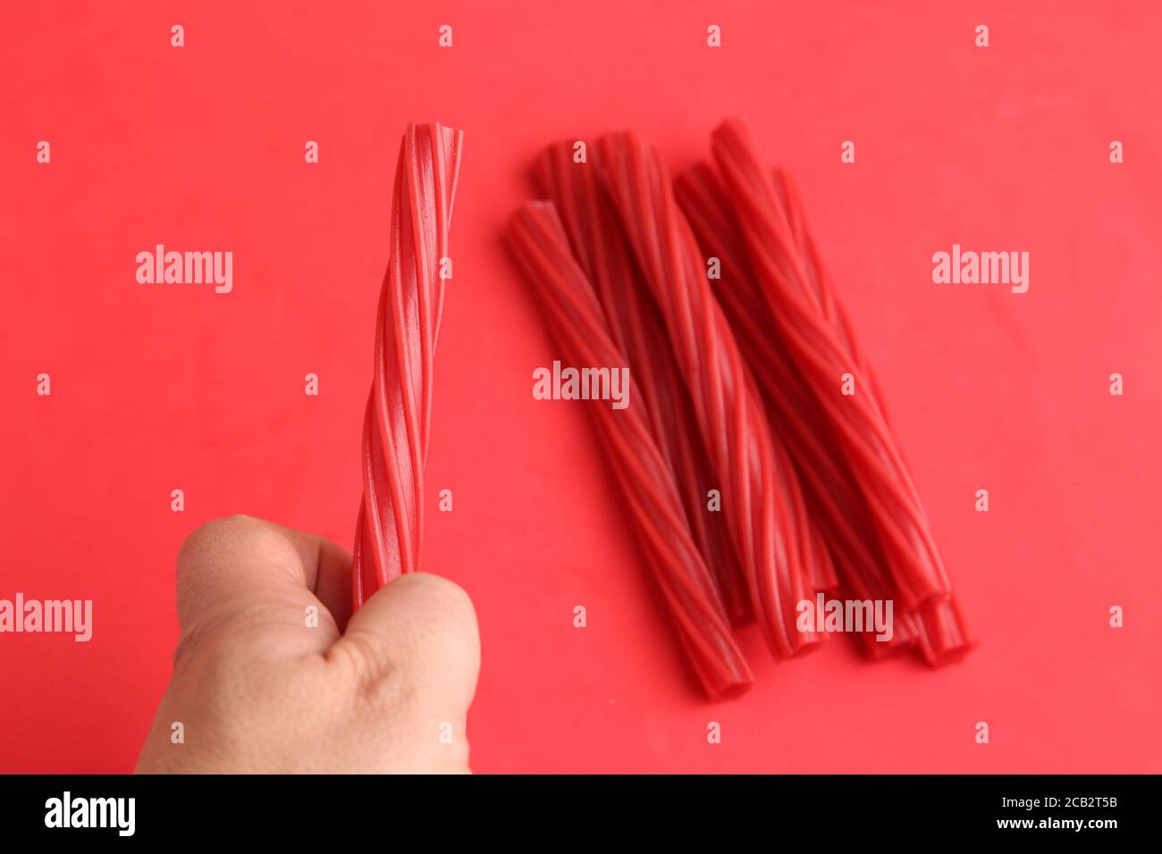 Red gummy licorice sticks on a red background Stock Photo Alamy