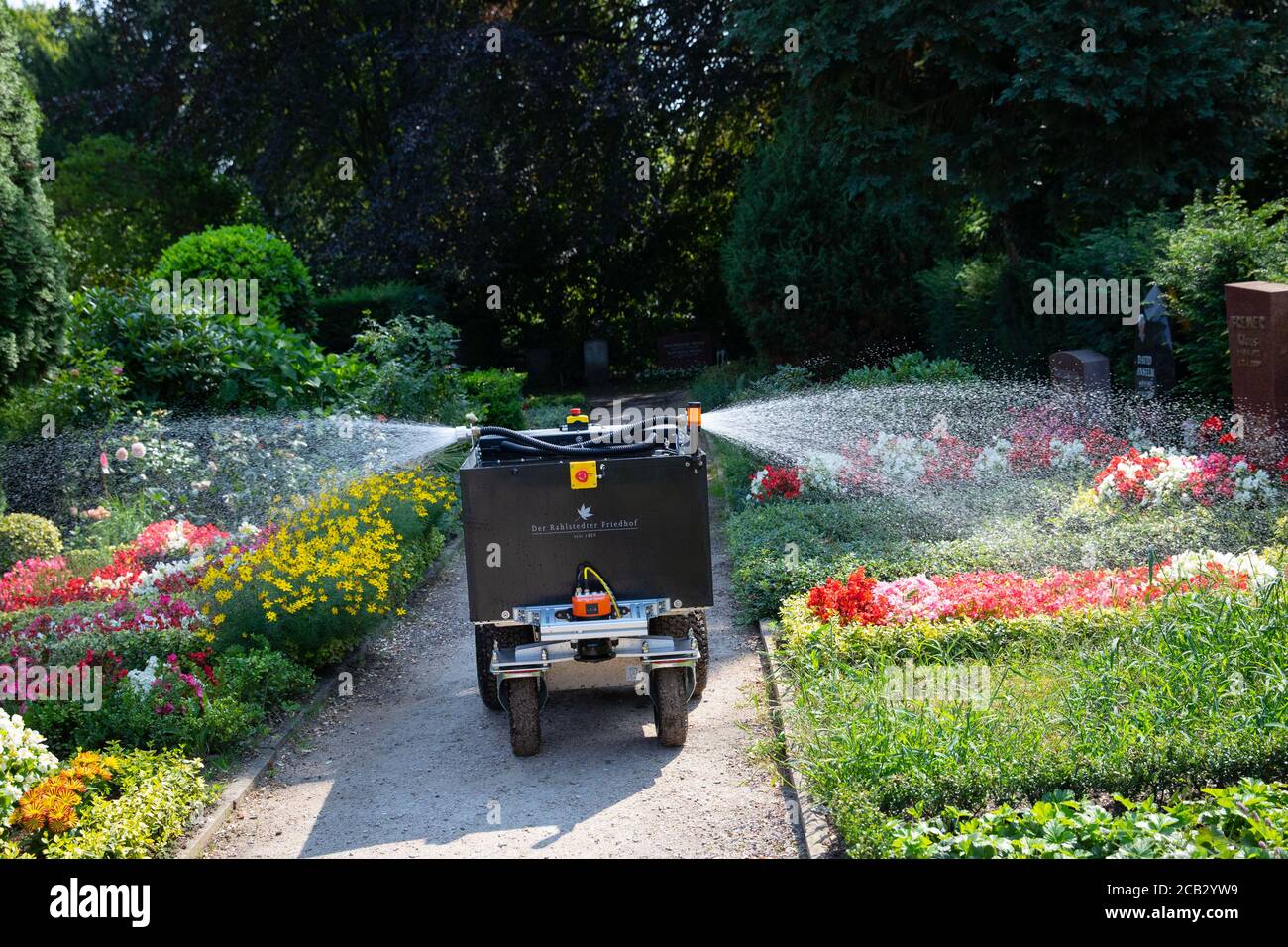 Hamburg, Germany. 10th Aug, 2020. The watering robot 'Rainos' drives between the graves during a photo session at the Rahlstedt cemetery and waters the plants. The autonomous vehicle with its 200-litre tank drives through the rows at the cemetery at night between 10 p.m. and 6 a.m. and waters a predetermined amount of water at previously programmed grave sites. Credit: Christian Charisius/dpa/Alamy Live News Stock Photo