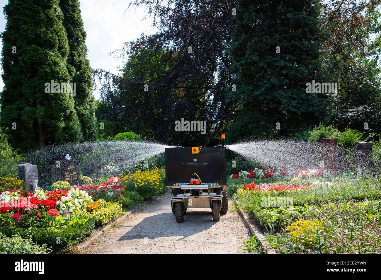 Hamburg, Germany. 10th Aug, 2020. The watering robot 'Rainos' drives between the graves during a photo session at the Rahlstedt cemetery and waters the plants. The autonomous vehicle with its 200-litre tank drives through the rows at the cemetery at night between 10 p.m. and 6 a.m. and waters a predetermined amount of water at previously programmed grave sites. Credit: Christian Charisius/dpa/Alamy Live News Stock Photo