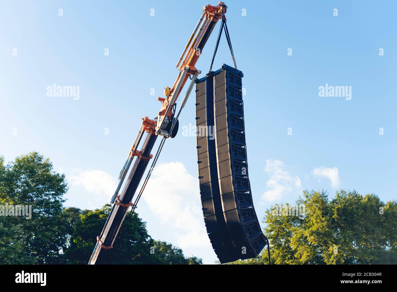 Concert sound system on construction crane at height outdoor with blue