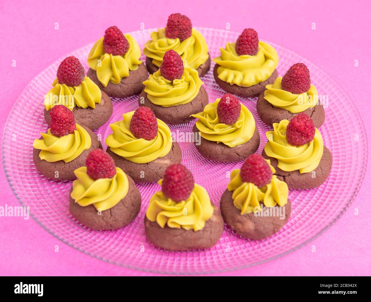 brown cookies with yellow cream and raspberries Stock Photo