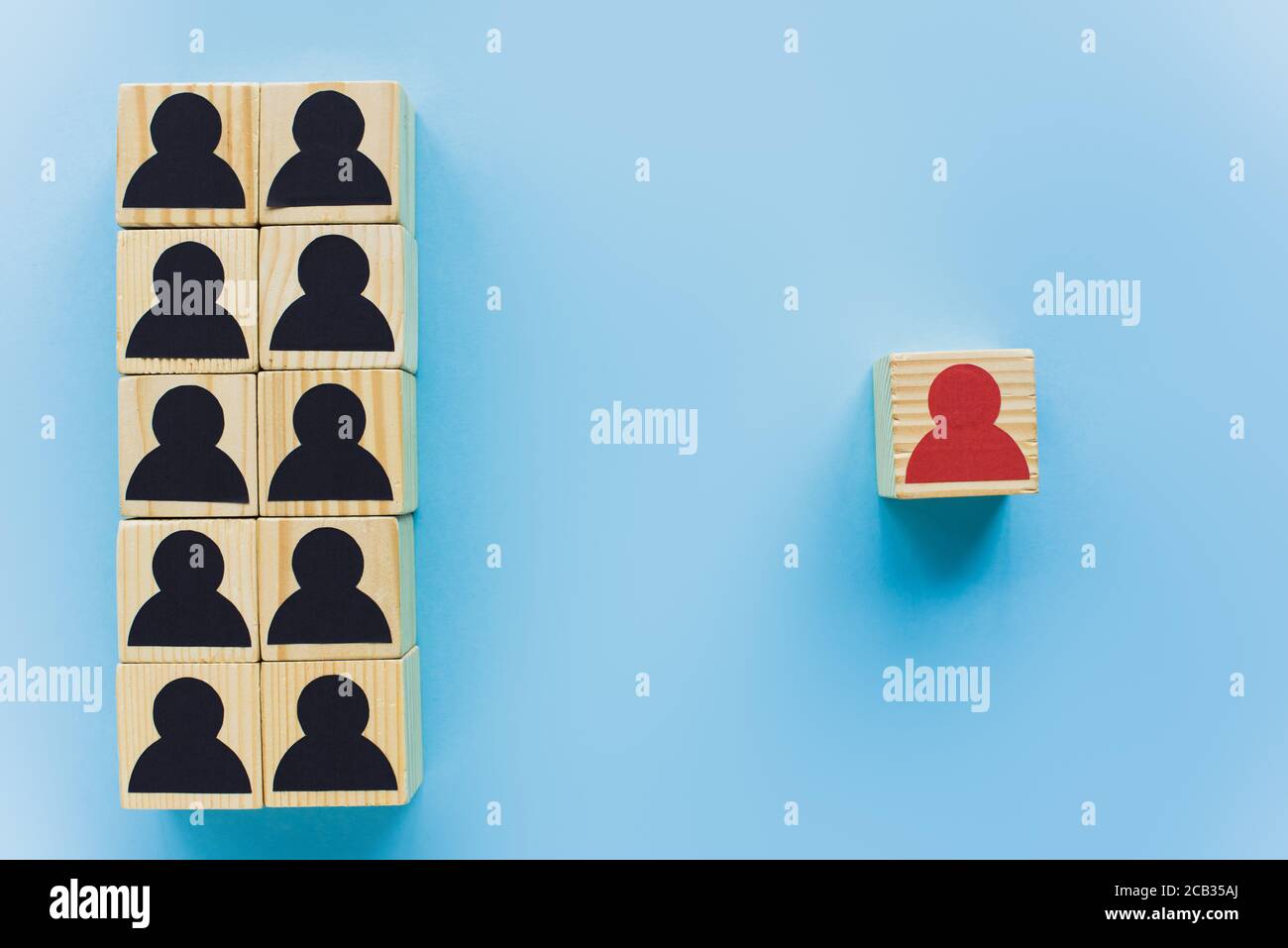 top view of wooden blocks with black and red human icons on blue ...