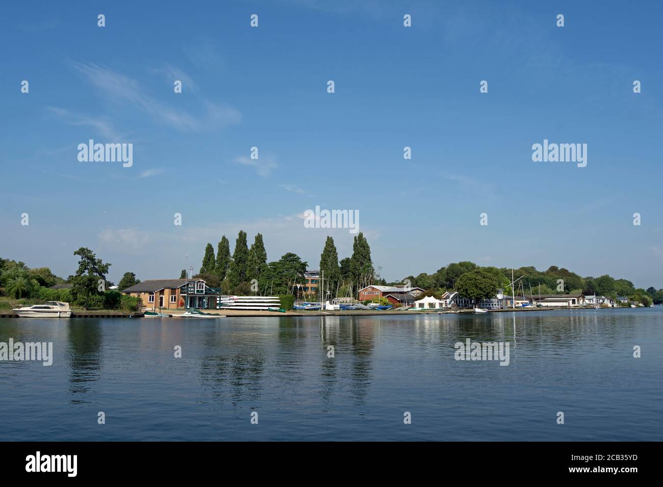 view across a tranquil river thames from ham, surrey, england, towards the rowing clubs of teddington Stock Photo