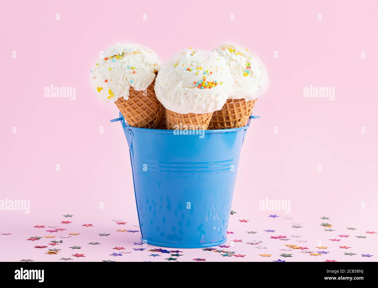 https://c8.alamy.com/comp/2CB38NJ/ice-cream-cones-in-a-blue-bucket-on-a-pink-background-decorated-with-stars-a-wafer-style-ice-cream-cone-2CB38NJ.jpg