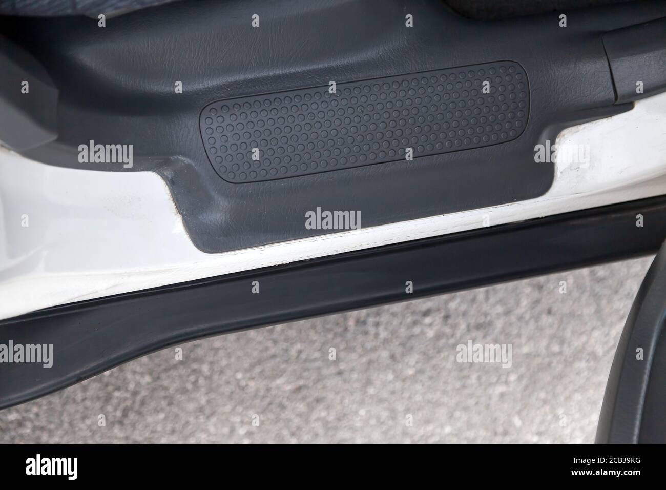 The open passenger door of a white Japanese crossover with a black