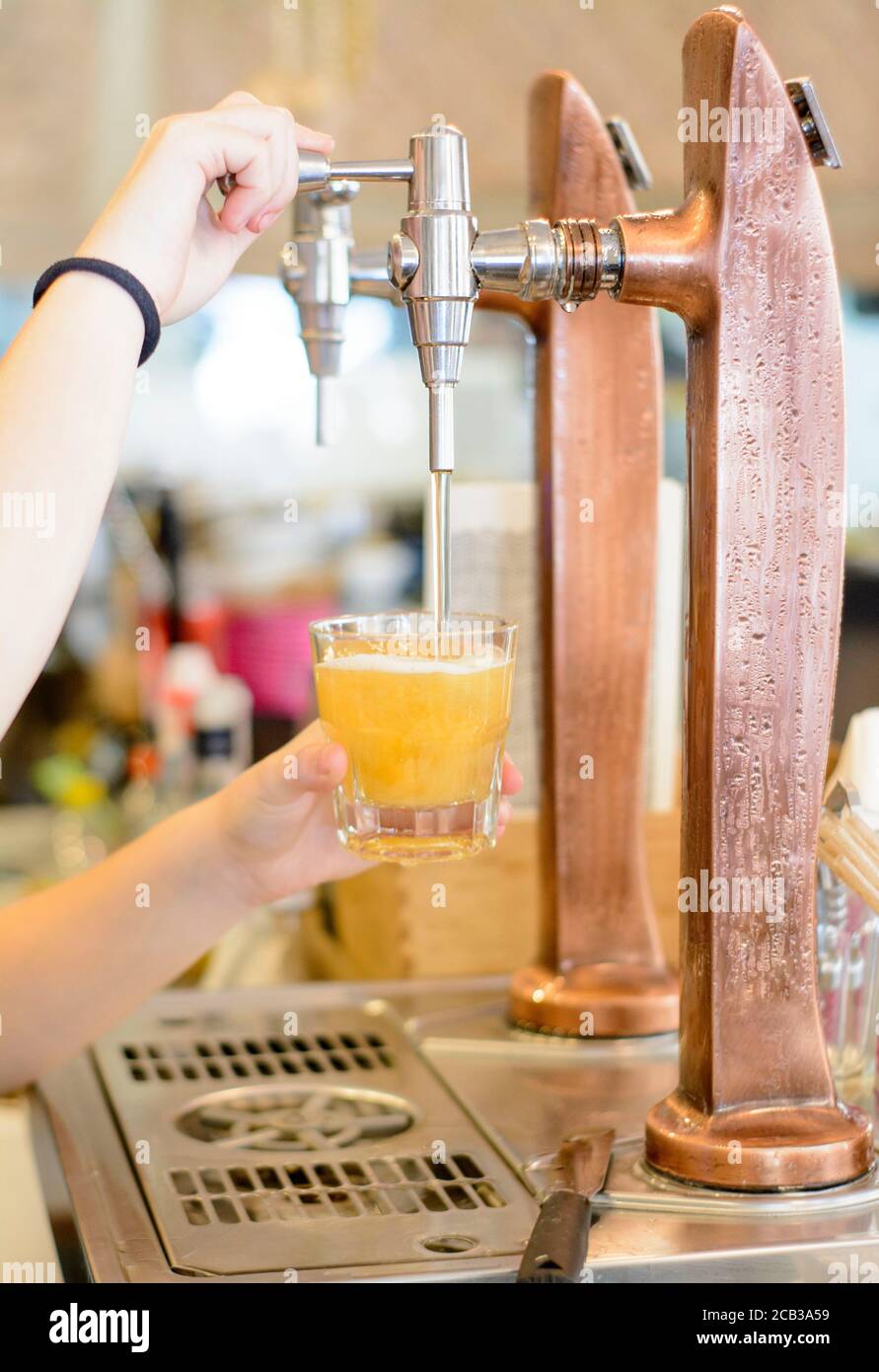 Fresh beer in glass from beer tap in a bar. international beer day. Saint Patrick day Stock Photo