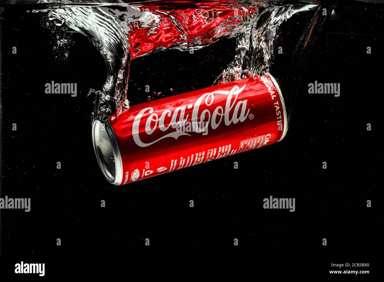 Coca cola can splashing in to water on black background Stock Photo - Alamy