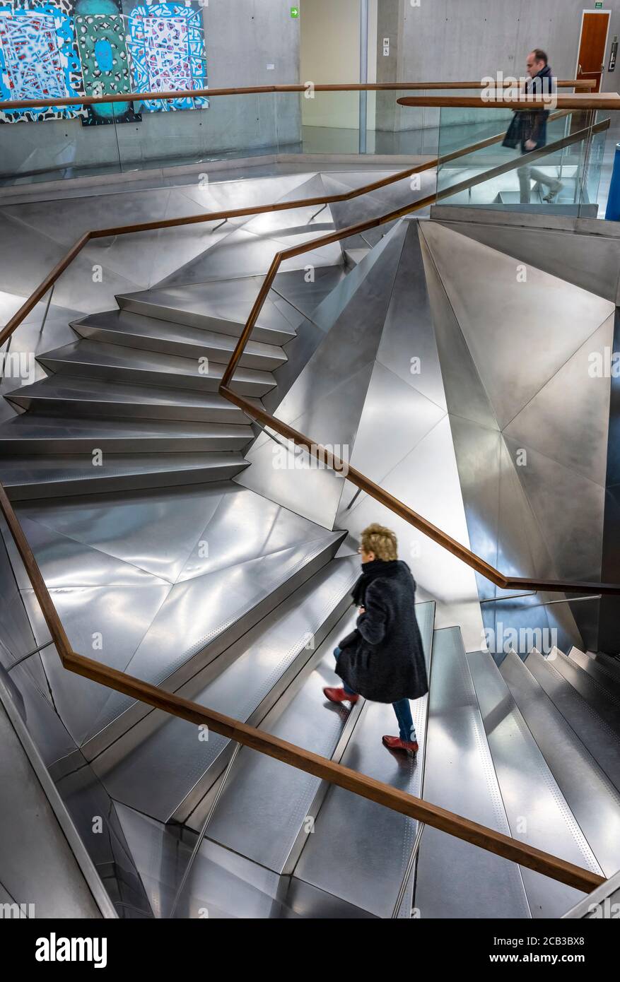 A visitor ascending the Interior entrance stairwell in the Caixa Forum Gallery and exhibition center Madrid, Spain. Stock Photo