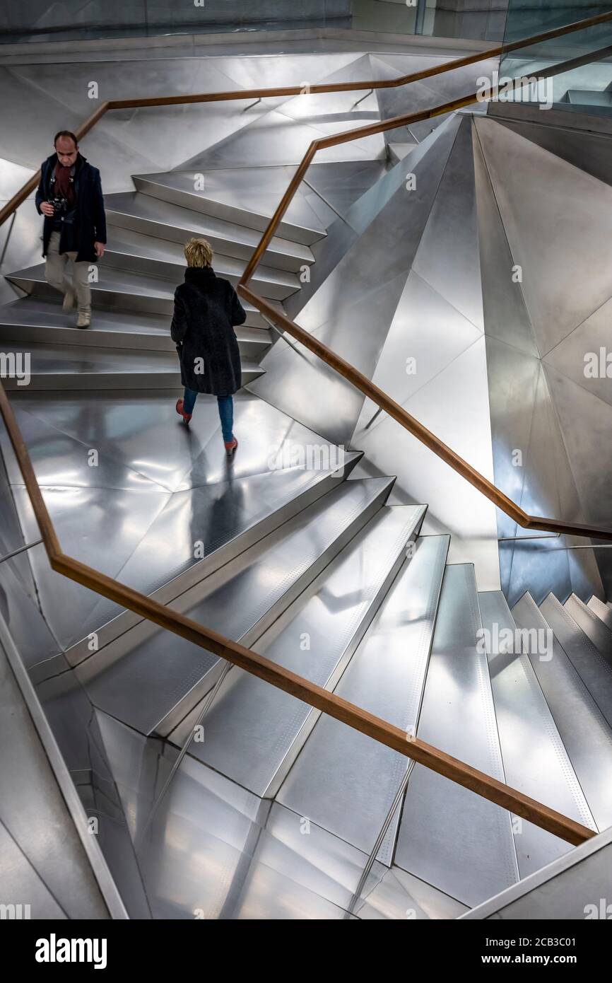A visitor ascending the Interior entrance stairwell in the Caixa Forum Gallery and exhibition center Madrid, Spain. Stock Photo