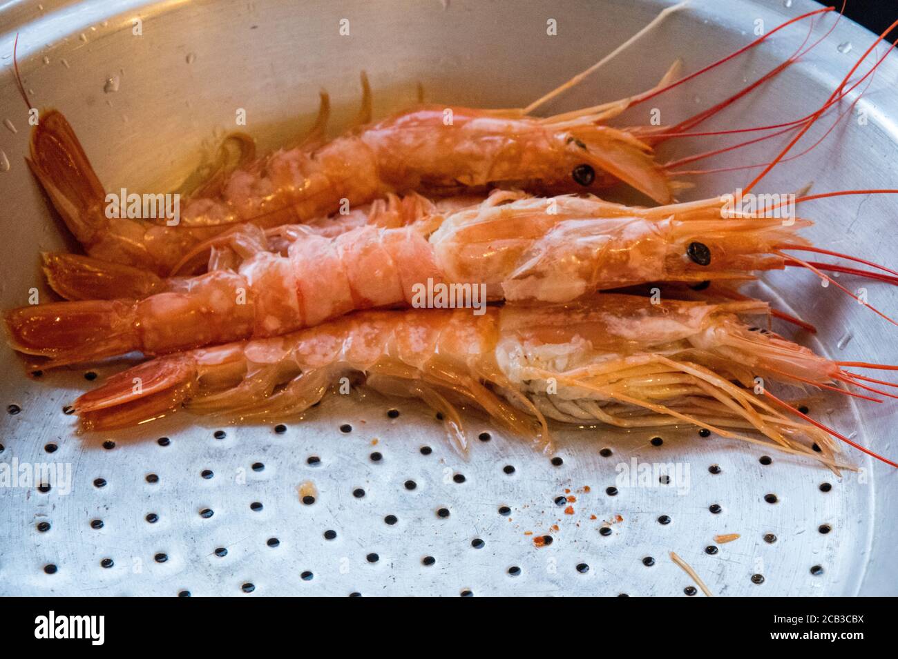 Nice sized prawns in a prep bowl ready for cooking.  Lovely color in the prep bowl with water residue. Preparation for a lovely seafood serving Stock Photo