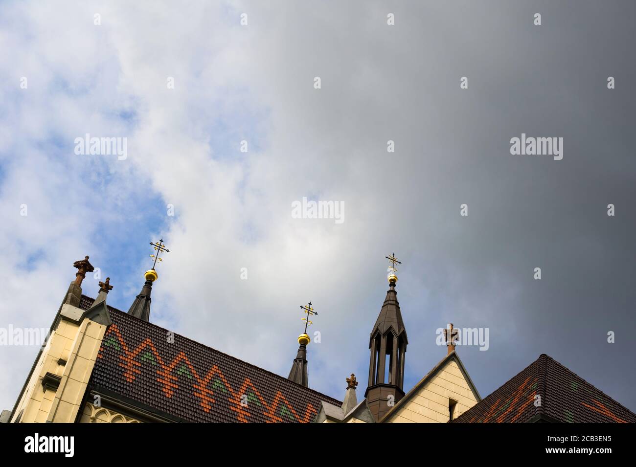 Roof of christian church - steeples and towers with spires and crosses on the top. Stormy sky with dark clouds as large copy space area Stock Photo