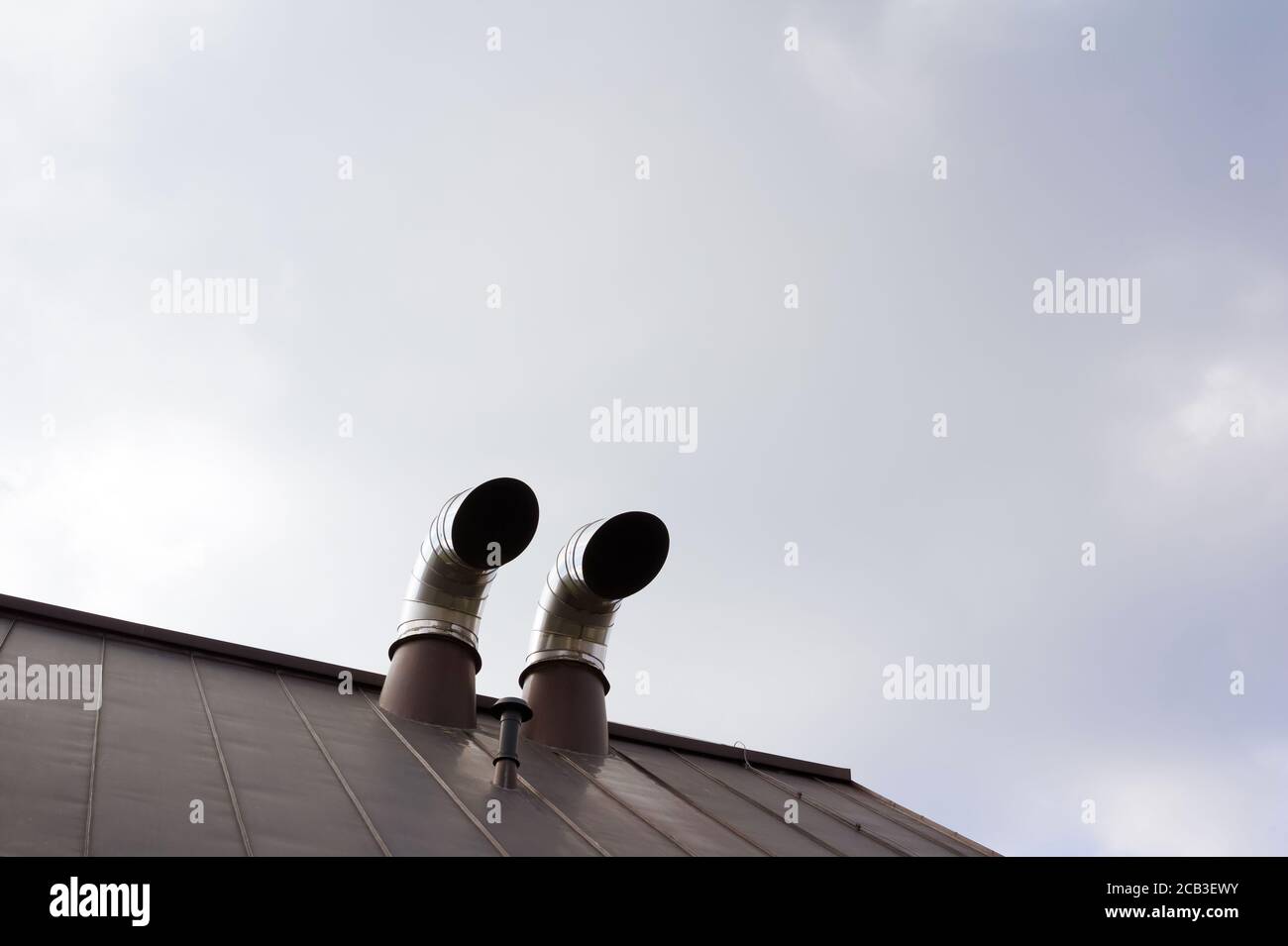 Rounded Ventilation pipe on top of the roof. Large area of sky as copy space Stock Photo
