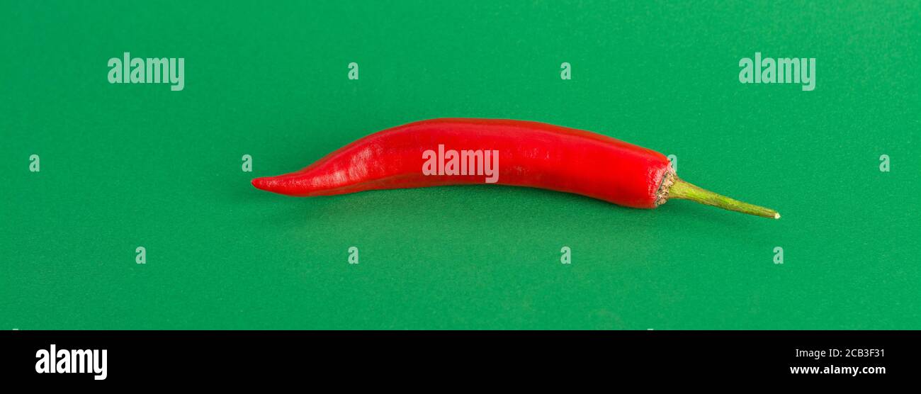 Red hot chili pepper on a green background. Web banner Stock Photo