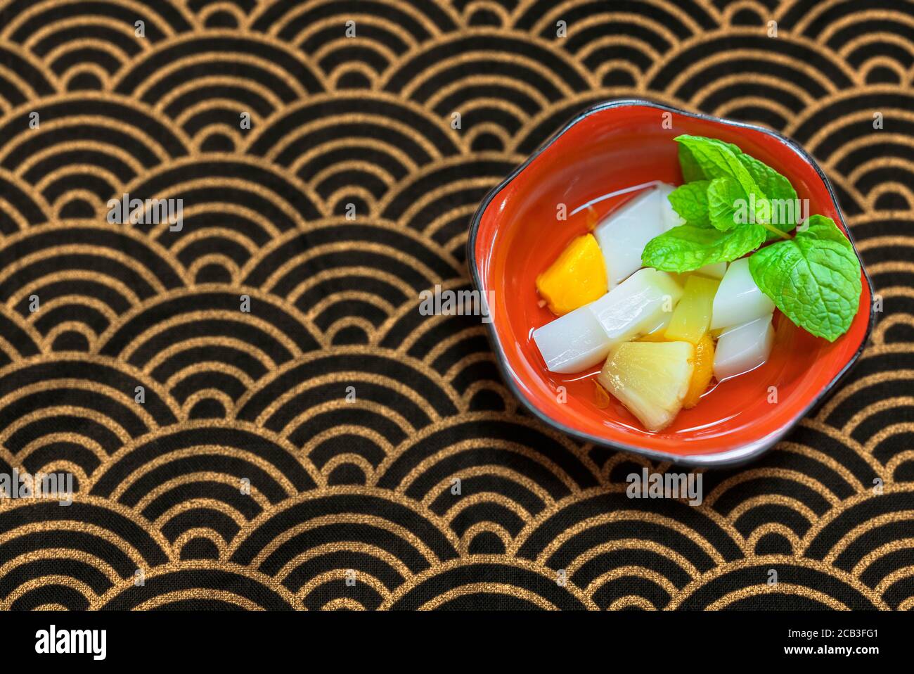 Japanese traditional dessert of Annin tofu or almond tofu made of apricot kernel milk, agar, and sugar with fruits pieces like pineapples and apricot Stock Photo