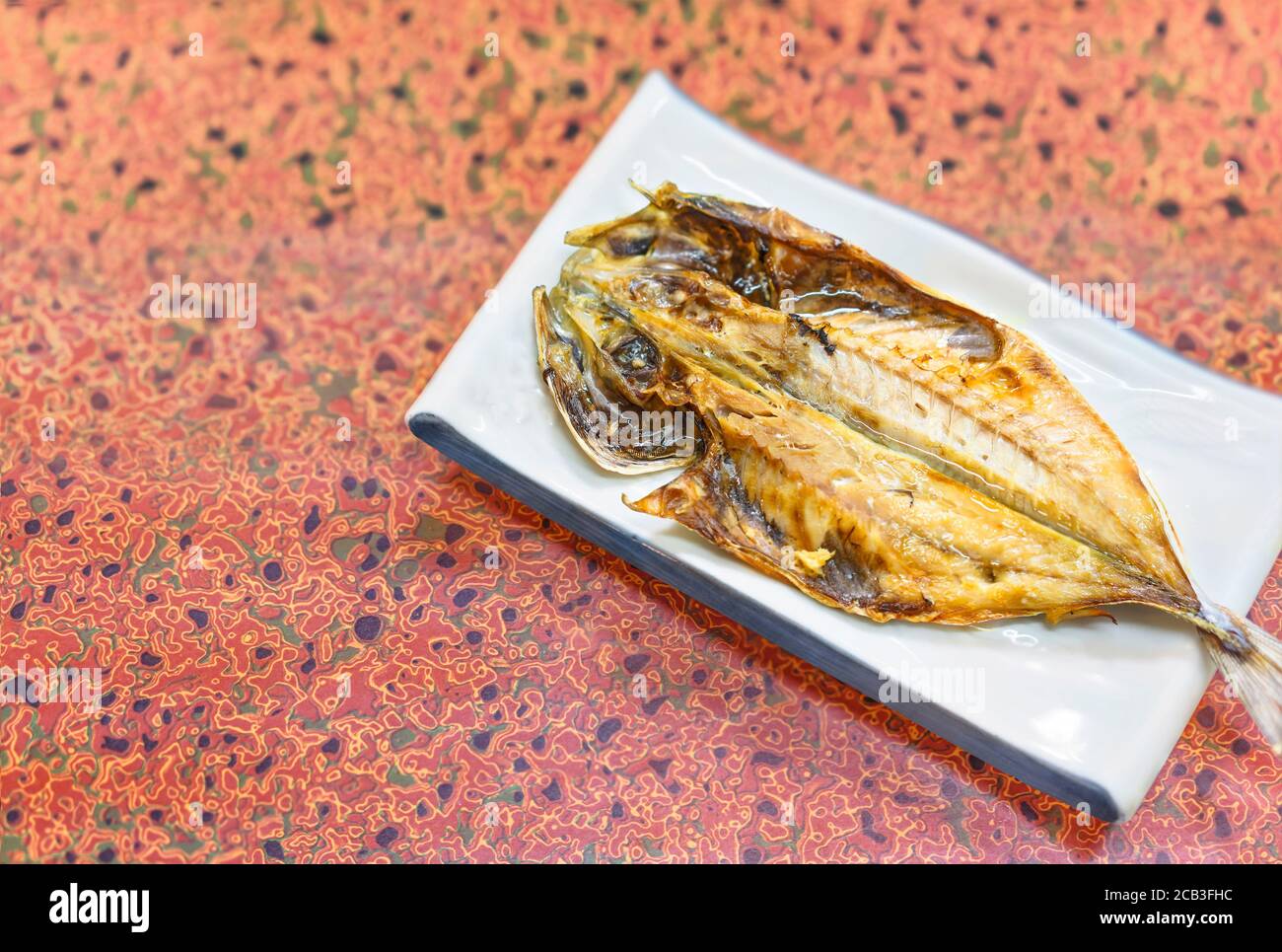 Japanese traditional grilled fish on a flower hemp leaf silver pattern table cloth. Stock Photo