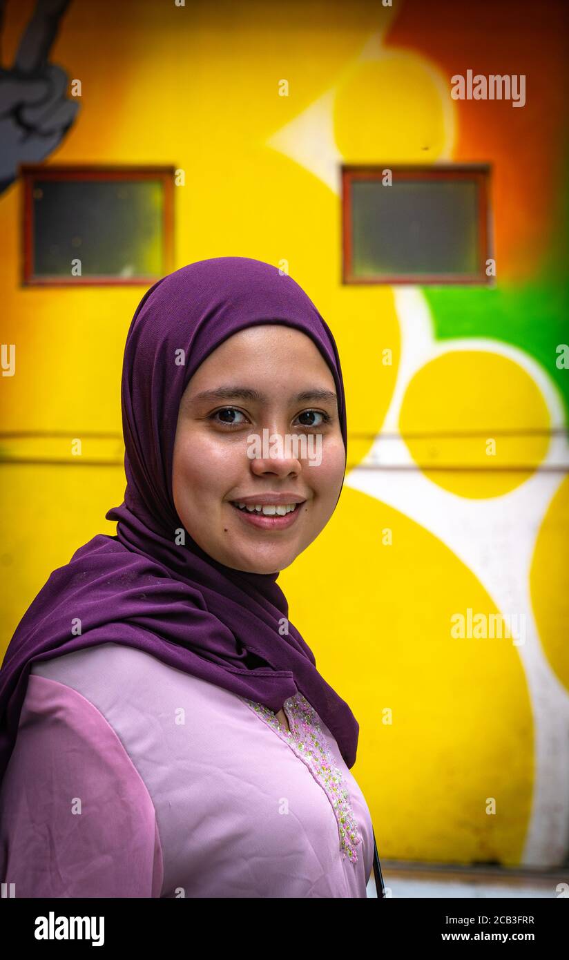 Kuala Lumpur/Malaysia/24 May 2020: Young beautiful Muslim Girl wearing a purple headscarf and a pink dress in Jalan Alor, Malaysia Stock Photo