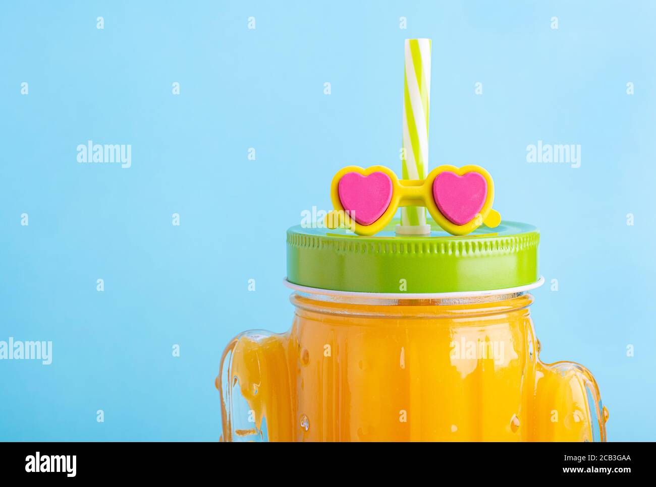 https://c8.alamy.com/comp/2CB3GAA/cactus-shape-mason-jar-with-orange-juice-a-jar-with-green-lid-and-straw-with-sunglasses-2CB3GAA.jpg