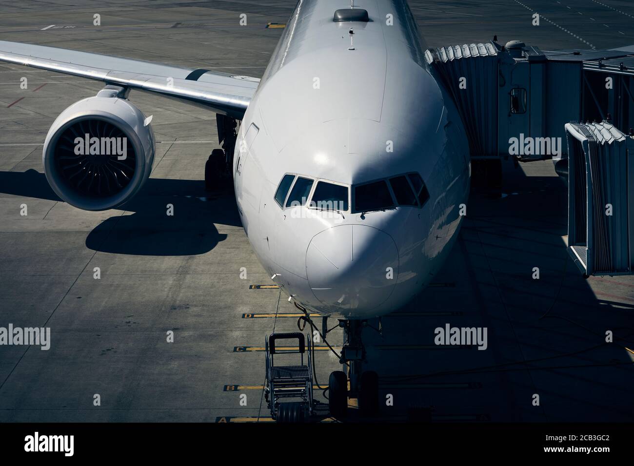 Front view od airplane at airport in drmatic light. Preparation passenger plane before flight. Stock Photo