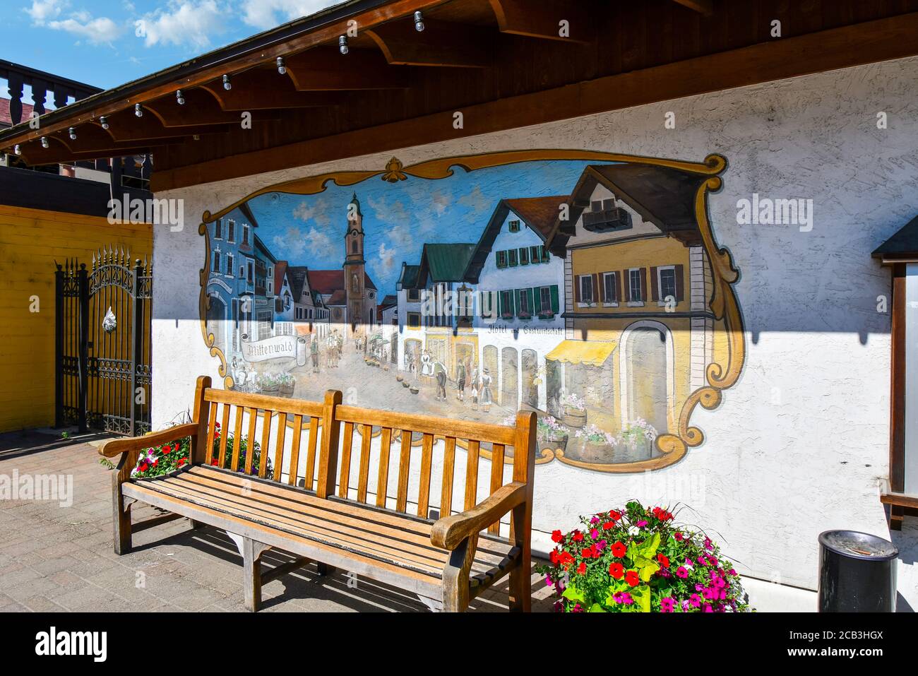 A bench with flowers and a colorful painted mural of the Bavarian themed Old Town in Leavenworth Washington, USA. Stock Photo