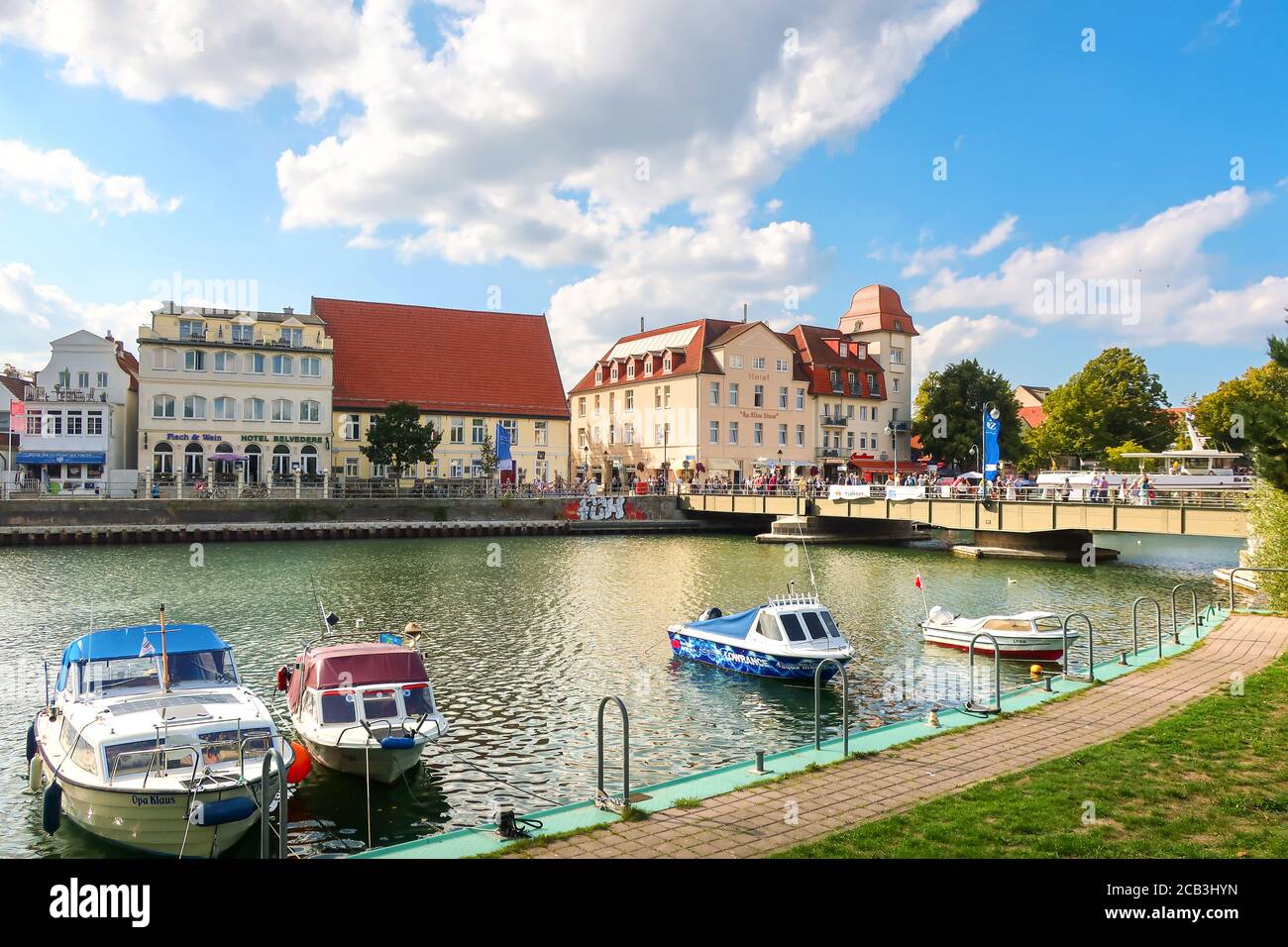 The colorful Baltic coastal village of Warnemunde Rostock, Germany, with boats in the Alter Strom canal and tourists enjoying a summer day. Stock Photo