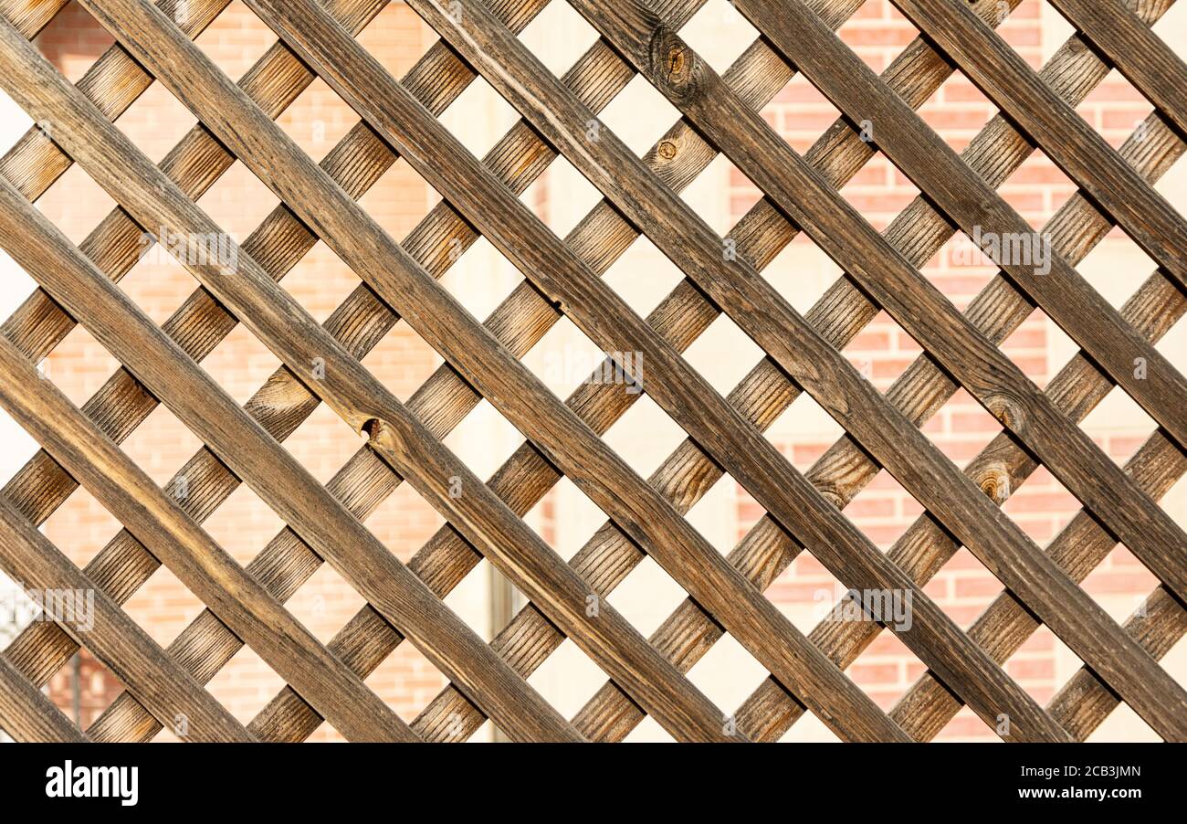 Wooden lattice on a brick wall background. Wooden texture Stock Photo
