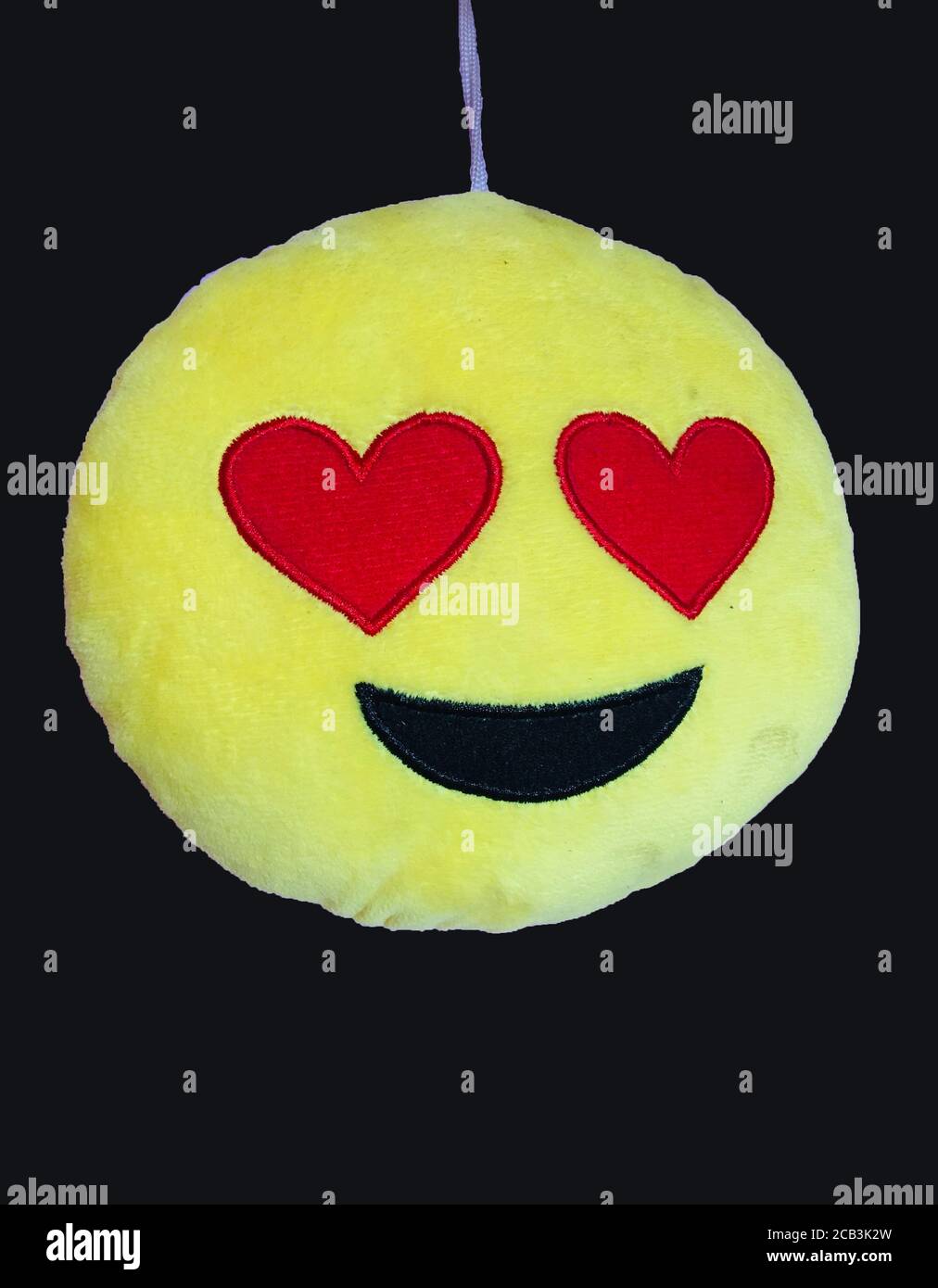 Smily Emoji Pillow with red love eye in black background. Stock Photo