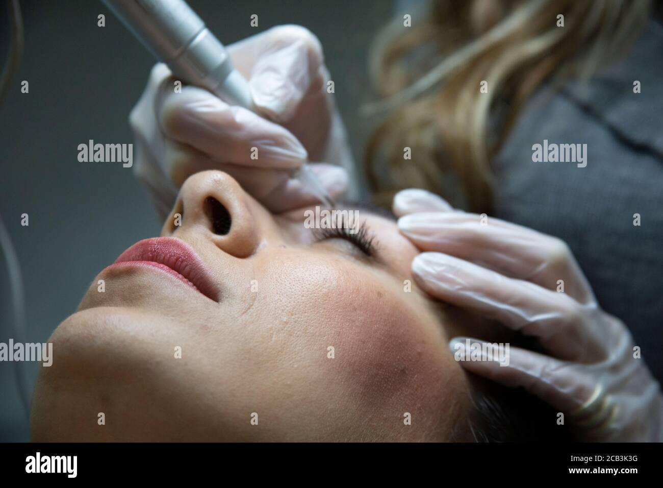 woman lying on couch at beauty salon with closed eyes and enjoying when ...