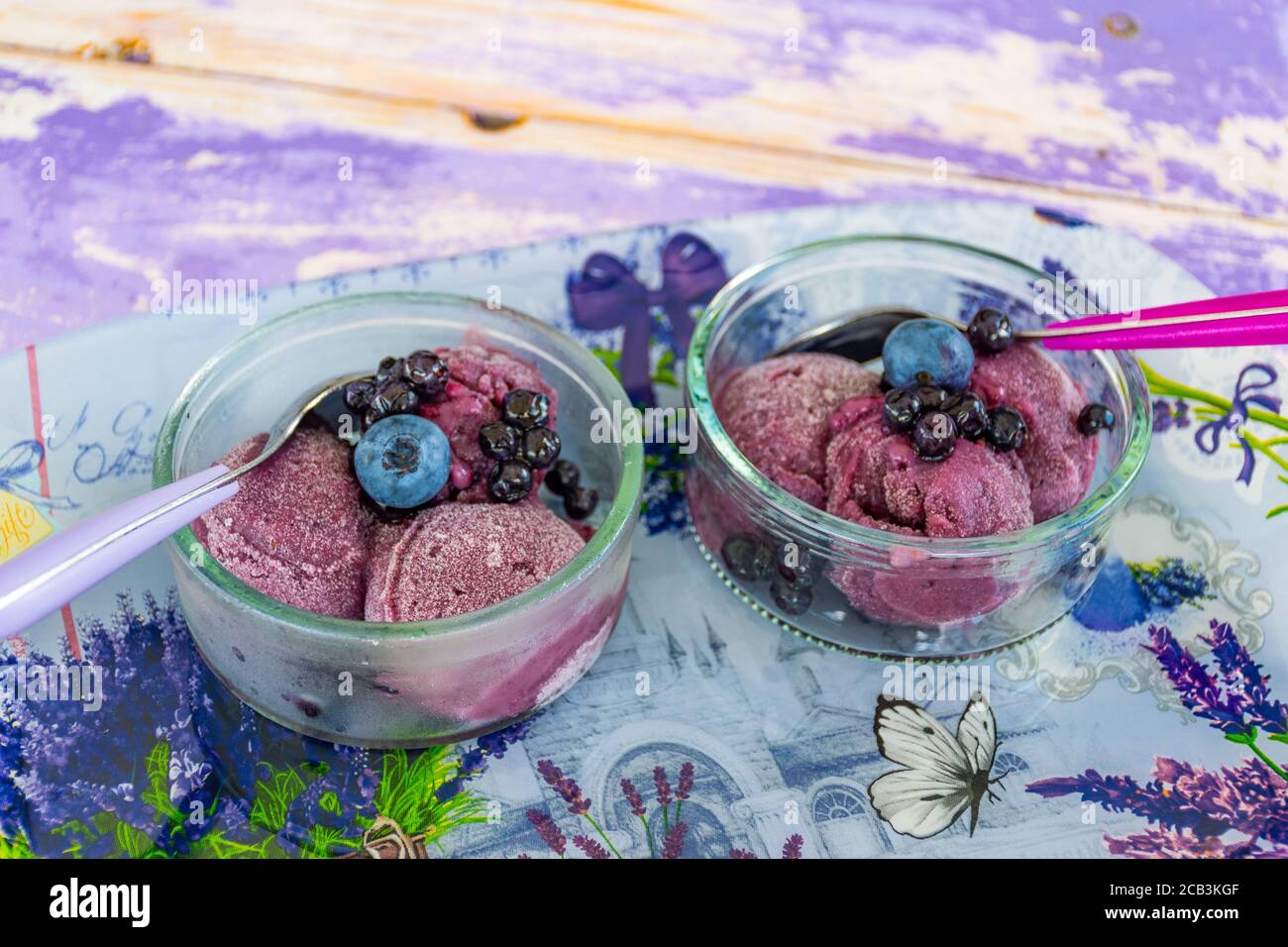 Delicious homemade lavender ice cream in a glass cup with blueberries and wild berries, close up Stock Photo