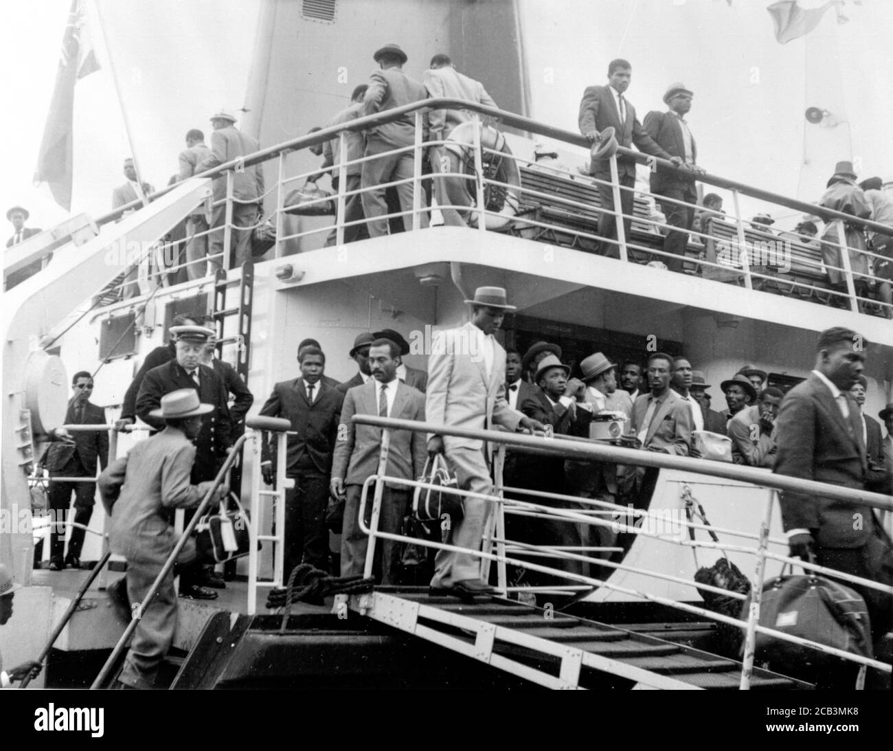 Men, women and children from the Caribbean arrive at Southampton in 1962 at the invitation of the British Government to help with rebuilding Britain after World War II. These people became the Windrush Generation due to their treatment by the British Home Office under a hostile environment policy where employers and other organisations were required to ask for visas. Stock Photo