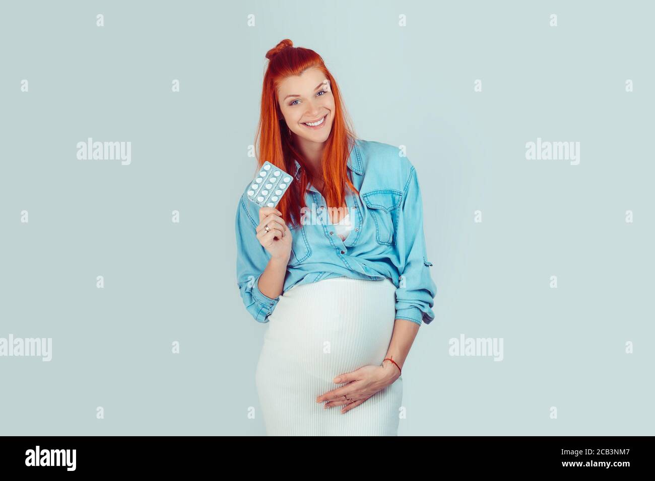 Vitamins and minerals suppliments during pregnancy. Content woman with