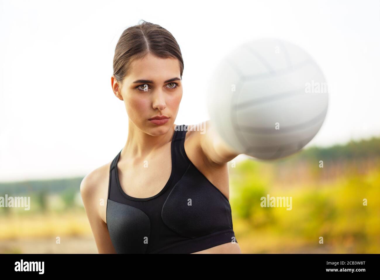 Girl athlete holding ball in outstretched hand Stock Photo