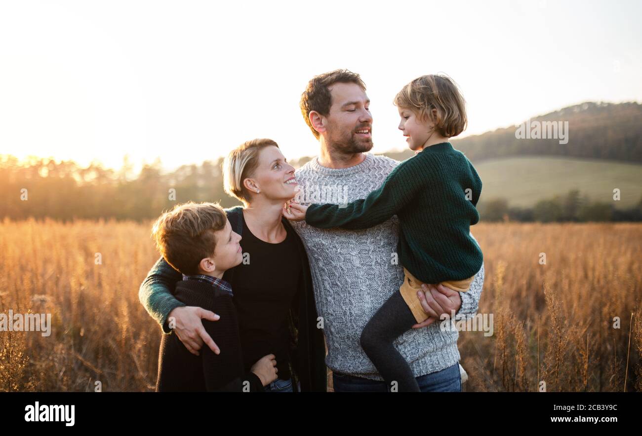 Beautiful young family with small children on a walk in autumn nature ...