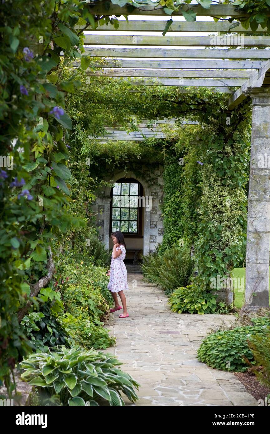 Little girl plays under the Edwardian Pergola, designed by Harold Peto, West Dean Gardens, West Sussex Stock Photo