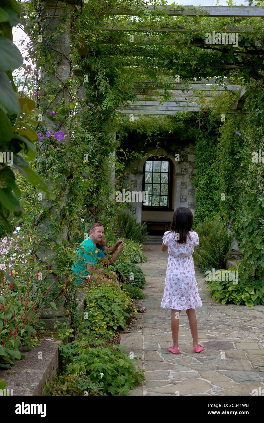 Family relax beneath the Edwardian Pergola, designed by Harold Peto, West Dean Gardens, West Sussex, England, UK Stock Photo